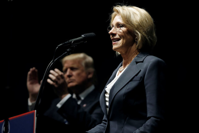 Donald Trump applauds as Betsy DeVos speaks at Trump’s “Thank You USA” rally in Grand Rapids, December 9, 2016. | Reuters/Mike Segar