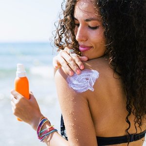 stocksy-bonninstudio-woman-applying-sunscreen-lotion-on-her-shoulder.jpg