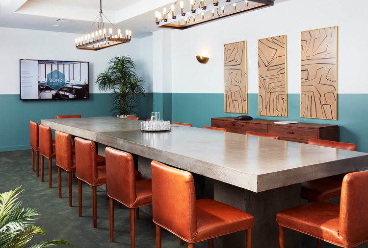 large conference table with orange leather chairs in turquoise and white modern office space