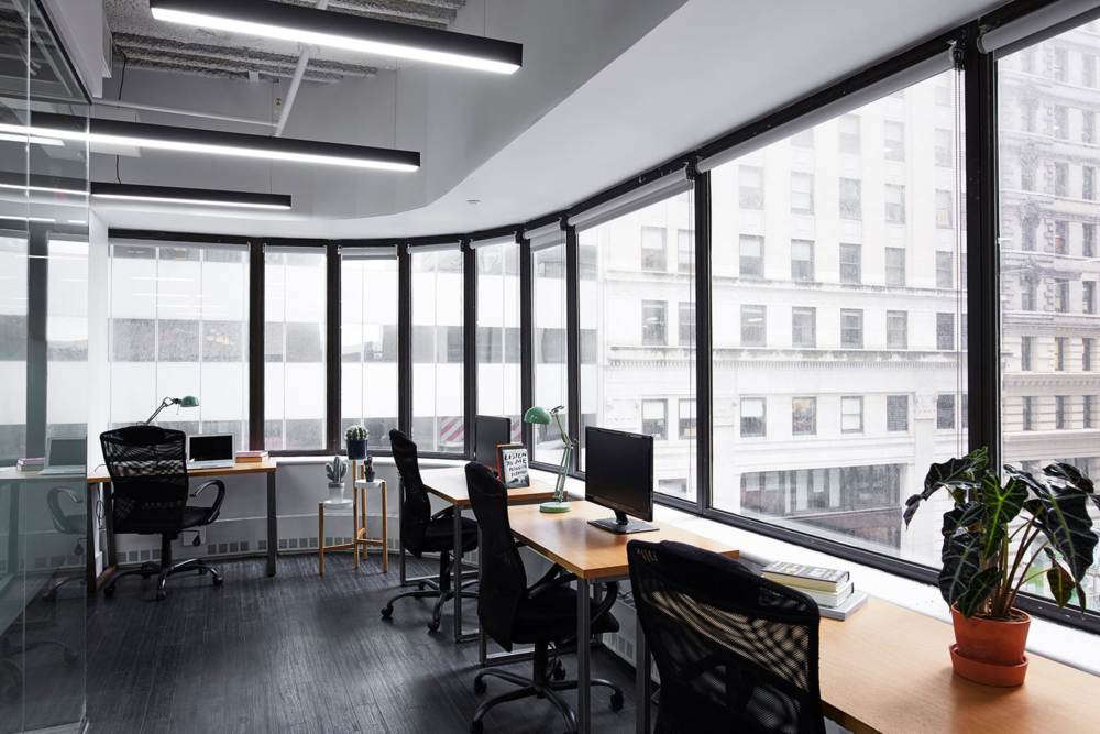 curved black and white office space with desks and large windows