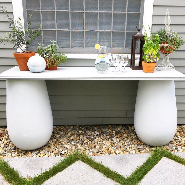 The console table I made... The two pedestals are old giant pots I repainted. And the actual table part is a wooden door I bought at Lowe's, with a pretty wooden trim that I added on for the edge. Voila! The perfect outdoor console table for some planted herbs and to prep food for the grill.