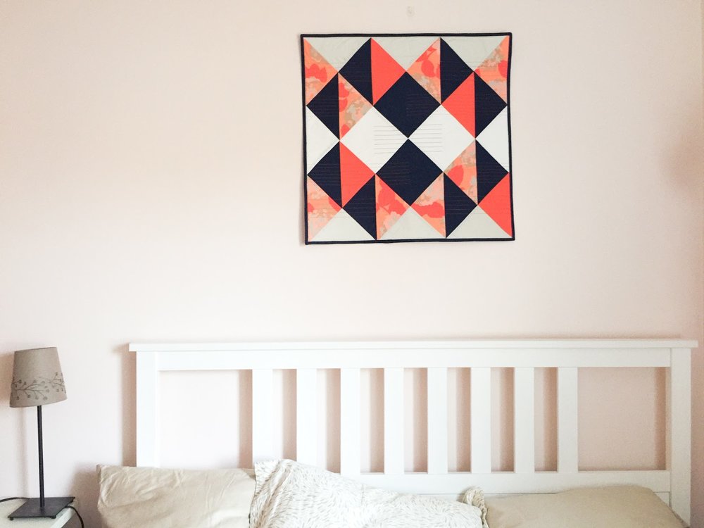 Modern Buckwheat coral and navy wall quilt living in its Boston home | by Lovely and Enough