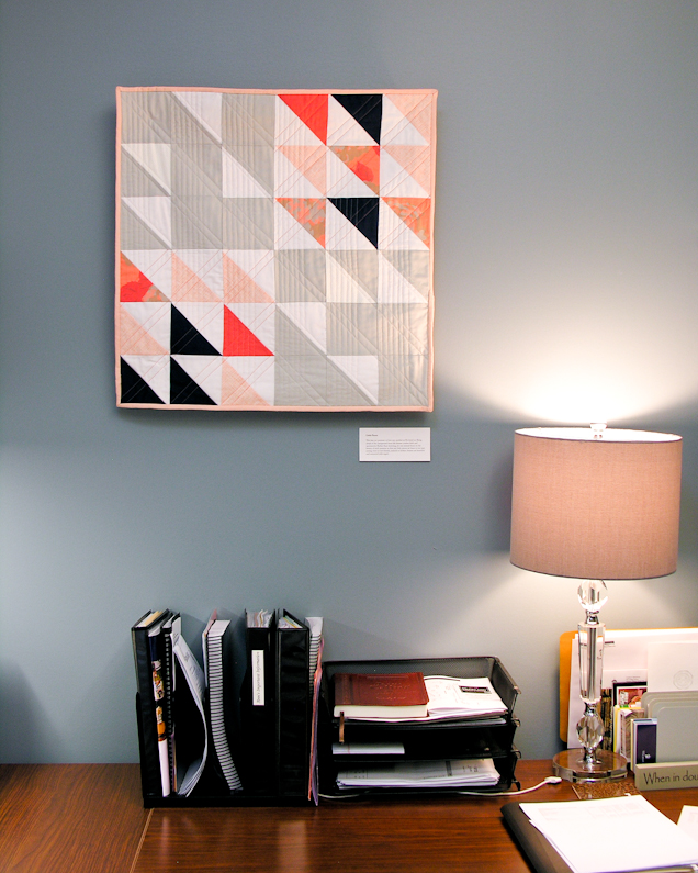Little Pieces coral and navy modern wall quilt living in its Wheaton College home | by Lovely and Enough