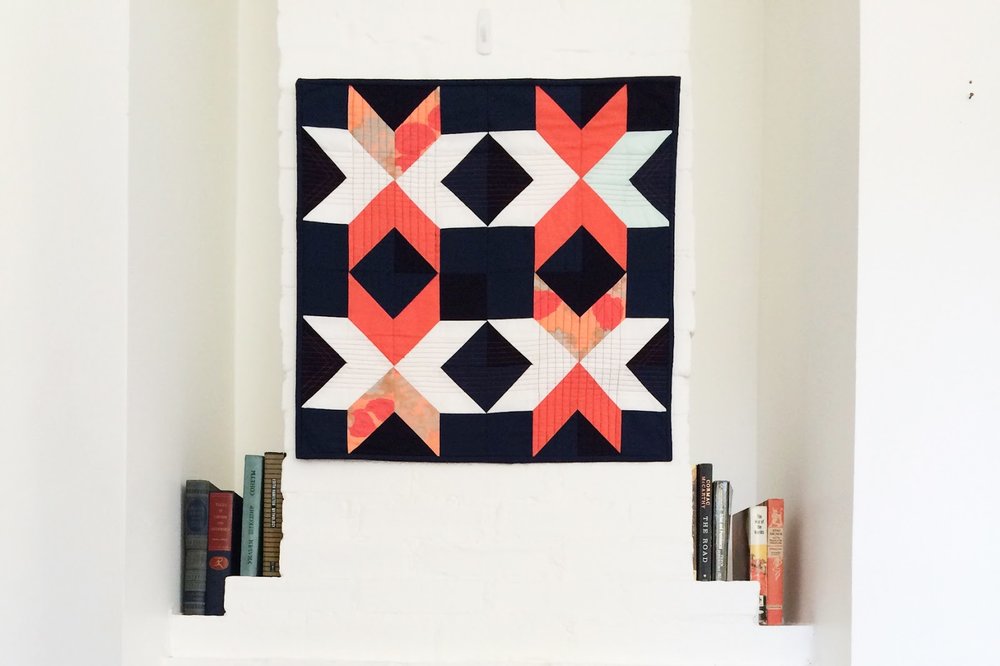 Dark Star coral and navy modern wall quilt living in its Mississippi home | by Lovely and Enough