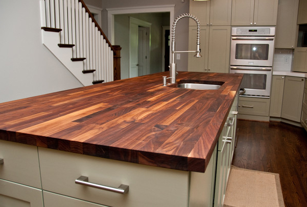 Butcher block counters add warmth to painted cabinets.