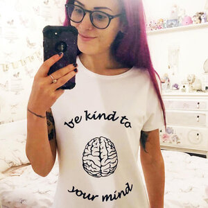 Photo of Cara Lisette wearing a t-shirt which reads, 'be kind to your mind'