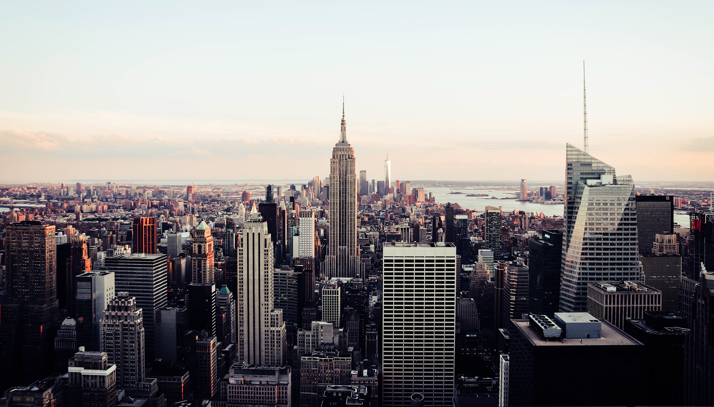 A distance view or New York City featuring a clear sky and the Empire State Building.