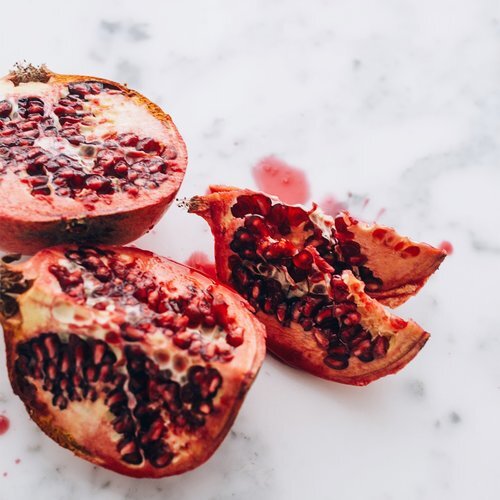 A still image of a cut-open pomegranate on a marble counter.