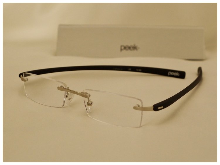 pair of rimless reading glasses with silver coloured nose-bridge.