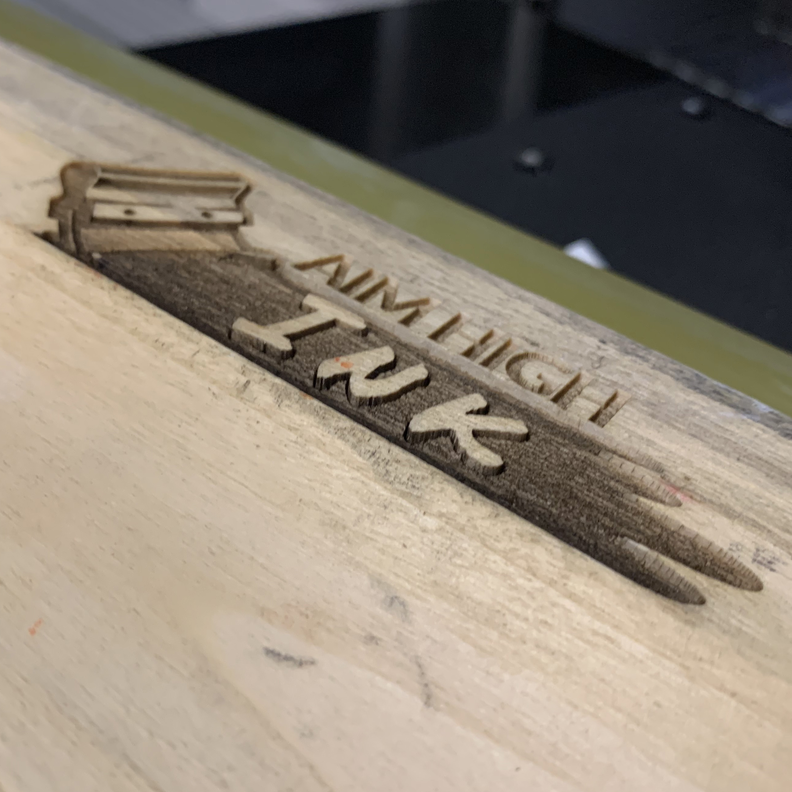 Laser Engraving: Aim High Ink's logo engraved on a wooden squeegee