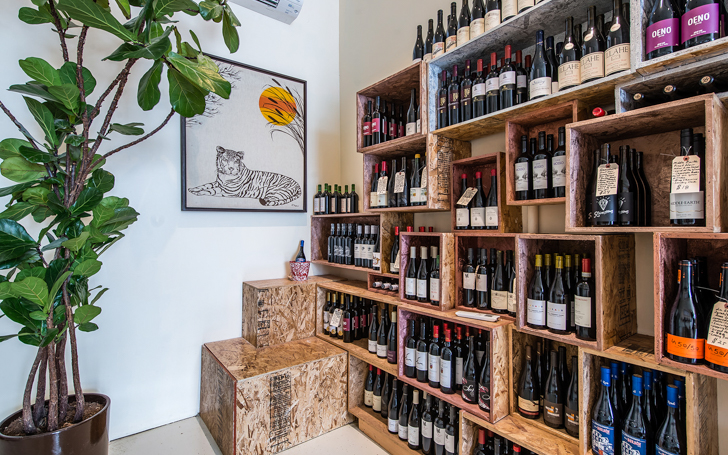 Back right corner of Vinovore showing a tiger painting, and shelves of wine