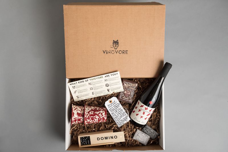 Vinovore gift box with a bottle of wine, dominos, wine tasting notes and other small gift ideas