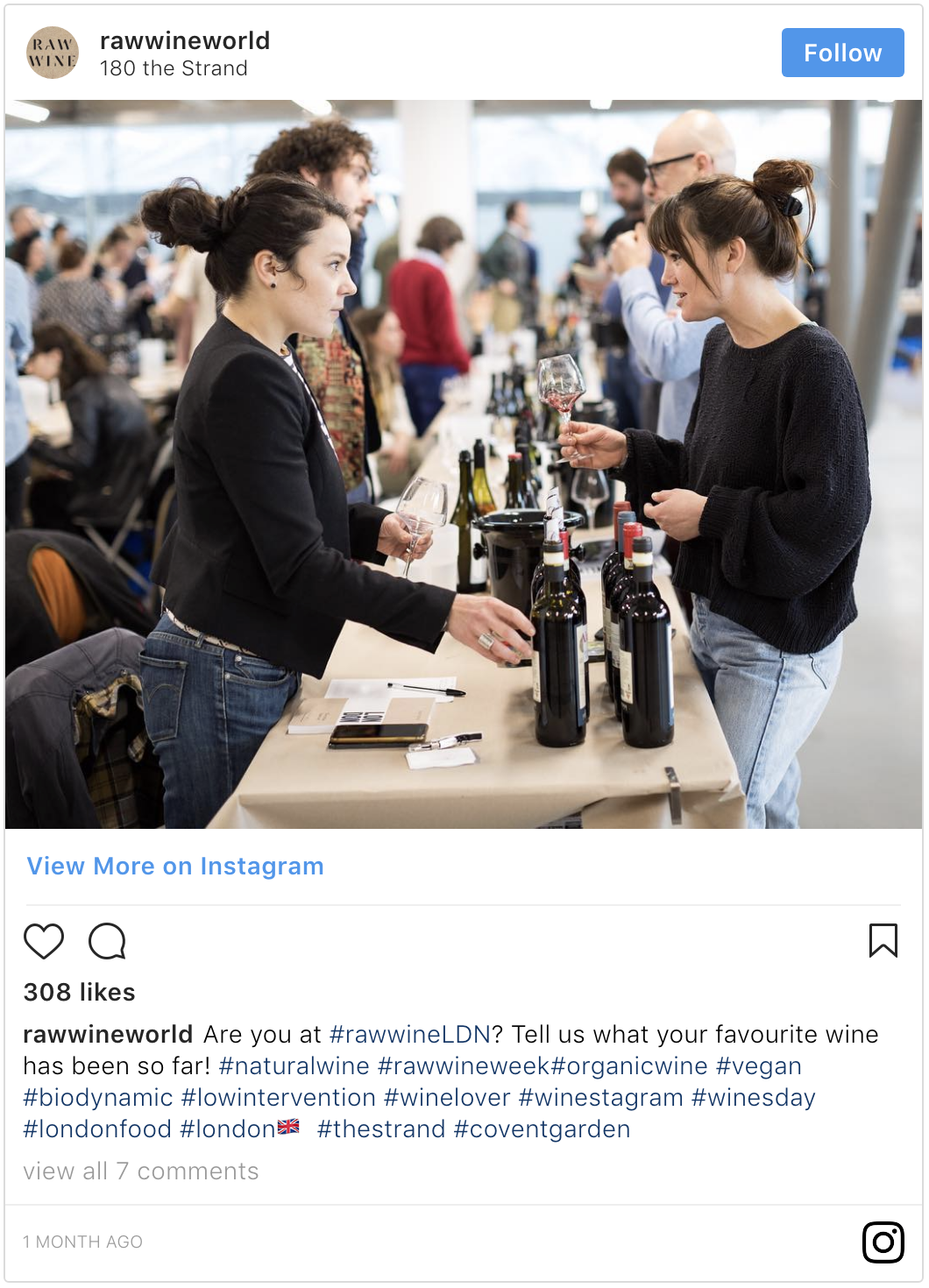 Woman in a black top with a big bun getting a pour of wine at a tasting event