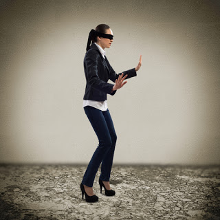 Blindfolded businesswoman stumbling along an empty room