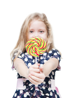 Little girl holding large lollipop and smiling