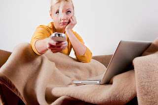 Girl with remote on couch, looking bored