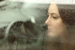 Woman looking sad through car window