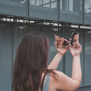Girl looking into broken mirror