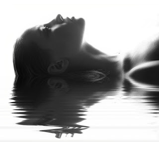 Woman floating on water, with reflection