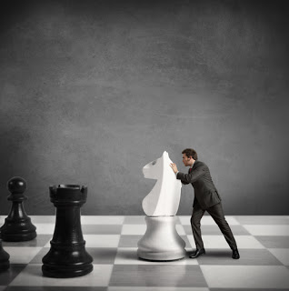 Man pushing pawn on giant chess board