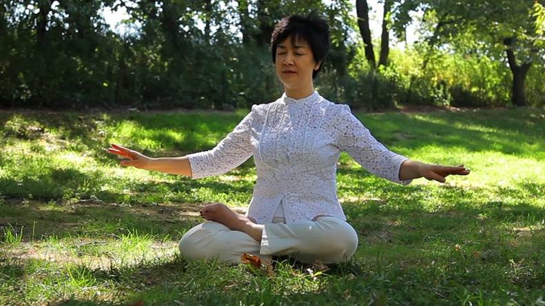 Screenshot from Free China movie showing Jennifer doing the 5th exercise of Falun Gong,   Reinforcing Supernatural Powers  .