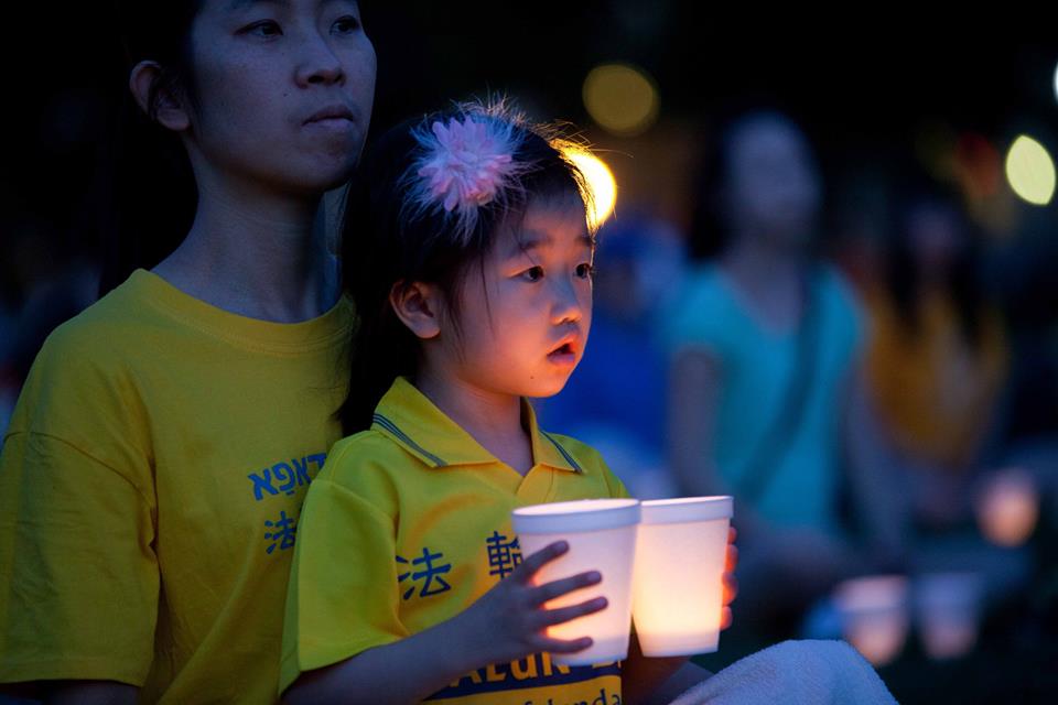 Dr. Charles Lee’s wife with daughter at the candle light vigil in Washington DC, July 2014, commemorating 15 years of persecution (photo by James Howard Smith)