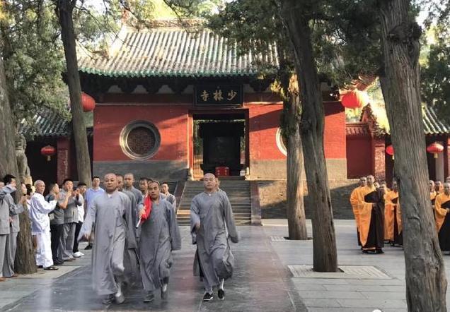 Monks in the famous Shaolin Temple in Henan Province in China march with a Chinese flag during a “Flag Raising Ceremony”. All religious groups in China are required to love the CCP first before they can love or worship their God or Buddhas. 河南少林寺和尚在舉行升旗儀式。在大陸，宗教人士被迫先愛黨，然後才能愛他們的上帝或神佛。