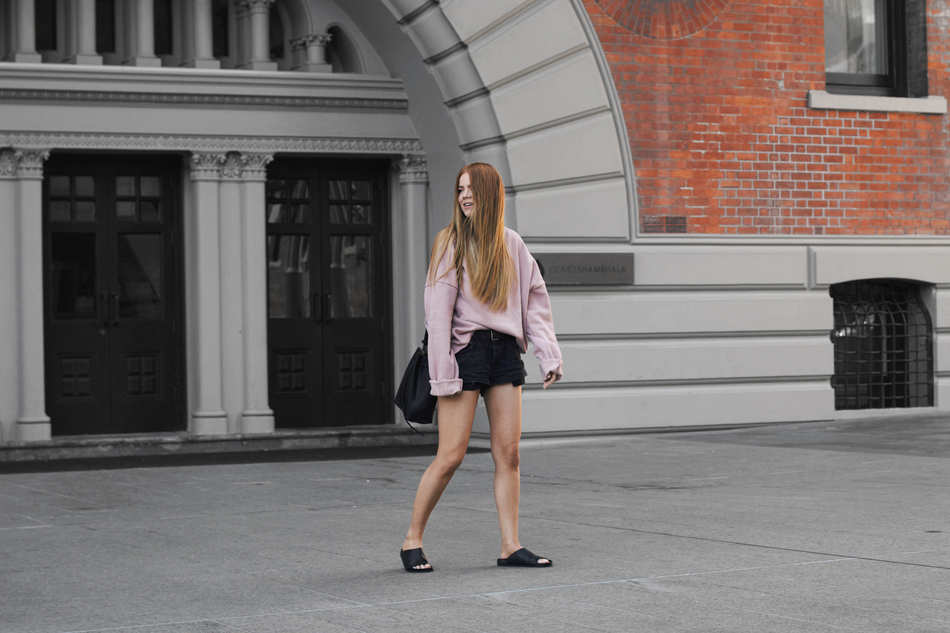Pink oversized sweater, GRLFRND slouchy shorts, bucket bag, The Mode Collective Dilan slides