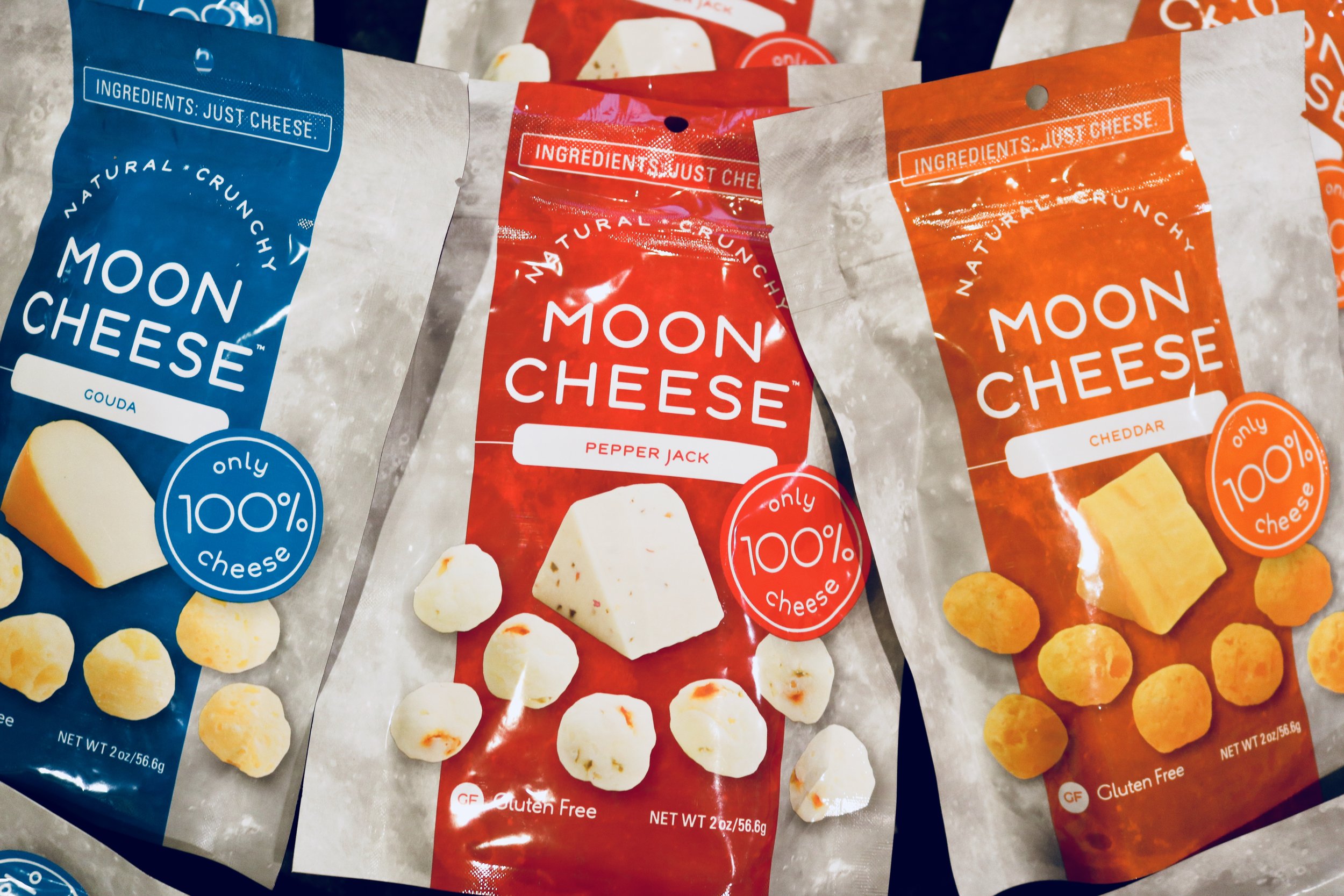 An assortment of Moon Cheese Snacks in Gouda, Pepper Jack and Cheddar flavors