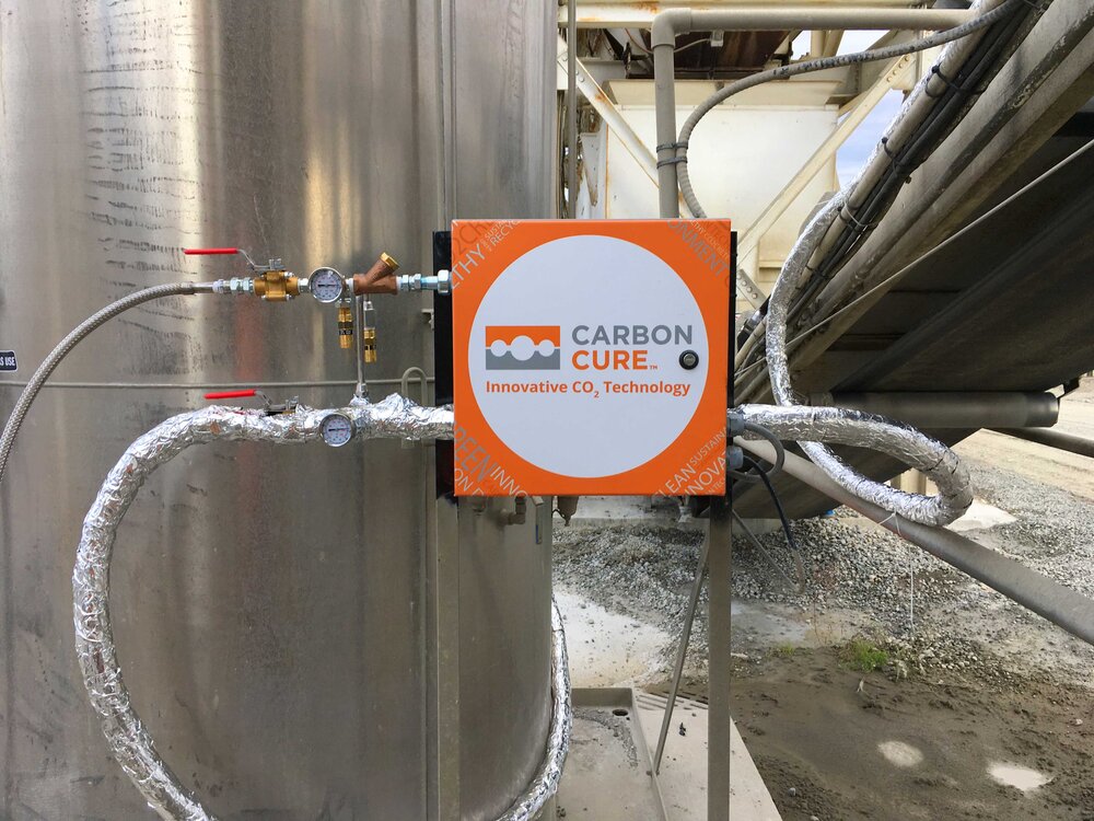 The CarbonCure valve box hooked up to the CO2 tank on one side and the injection nozzle on the other via insulated transfer hoses. The valve box is also connected to the control box by a control cable.