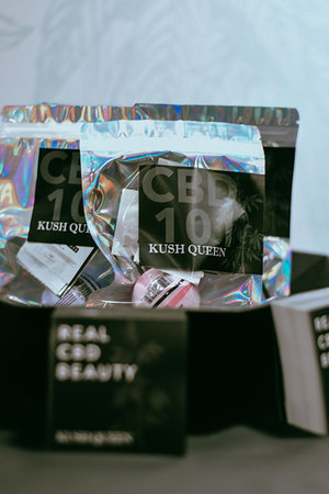 Kush Queen CBD 101 Kit featuring mini bath bomb and sample packet of Melt pain lotion, Soaked body wash, Defyn skin serum, & Foto Blur KINGDM Primer. 