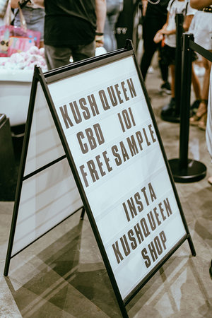 Sign reads "Kush Queen CBD 101 Free Sample, Insta @KushQueenShop