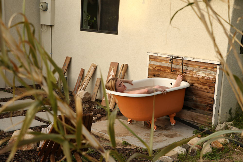 Model pictured relaxing in outdoor tub using Kush Queen bath bomb. 