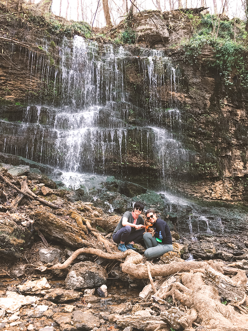 Kush Queen CMO Tiffany Whitmore pictured with wife in front of waterfall along their hike.