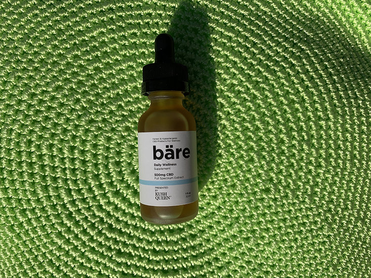 The best hypoallergenic CBD Tincture, bare pictured against a bright green plate charger.