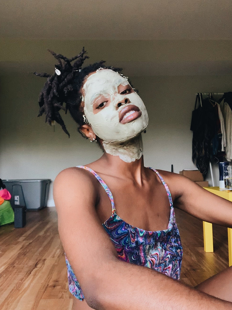 Womxn with dreads with a pore cleansing DIY CBD oil face mask.