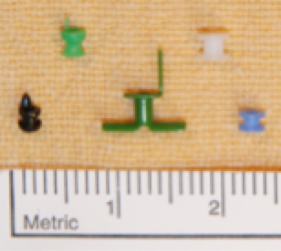 Figure: grommets of various sizes and designs. The white grommet at the top right is a Sheehy fluoroplastic collar button tube, the grommet most commonly used by Dr Smith.
