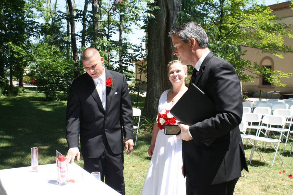 Ohio wedding officiant, Damian King, of Columbus talks to bride and groom, Danielle and Bill about their sand ceremony