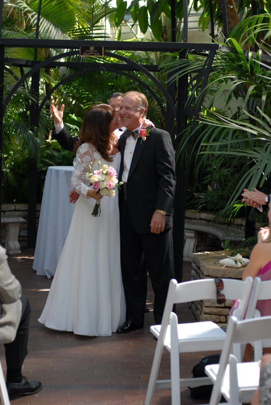 Wedding officiant Damian King watches Pam kiss Rick at Franklin Park Conservatory in Columbus Ohio