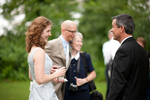 Bride chats with her wedding officiant near Columbus Ohio. Groom in background