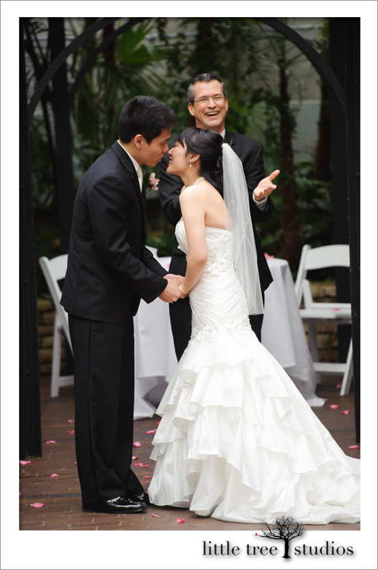 Bride and groom kiss in Columbus, Ohio, at Franklin Park Conservatory; wedding officiant Damian King presiding