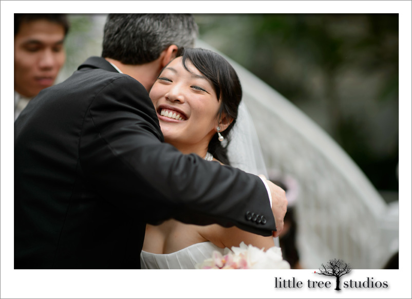 Happy bride hugs wedding officiant, Damian King, at Franklin Park Conservatory in Columbus Ohio