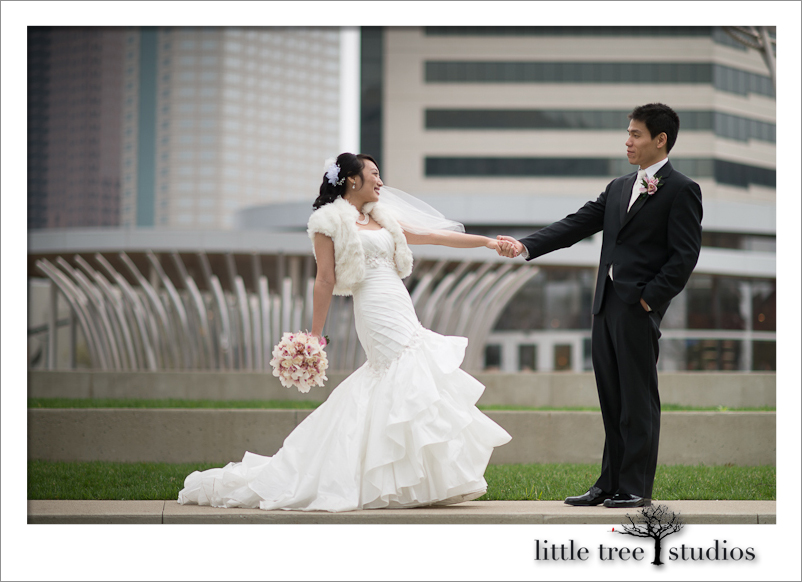 Groom and bride share a fun moment in downtown Columbus Ohio. Photo by Little Tree Studios