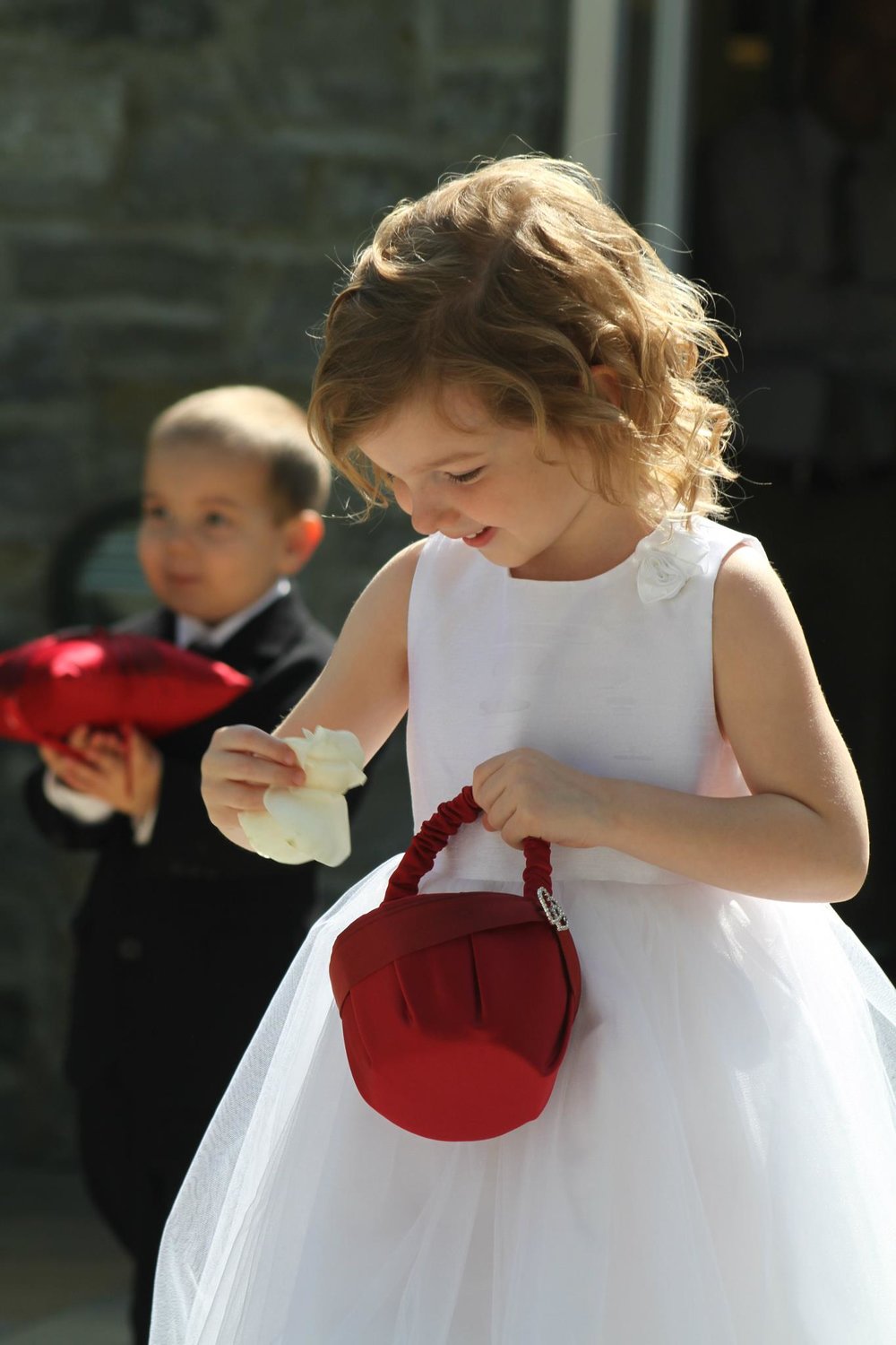 Fascinated flower girl enjoys Kendra and Nathan's wedding in Columbus Ohio while officiant Damian awaits bride's entrance