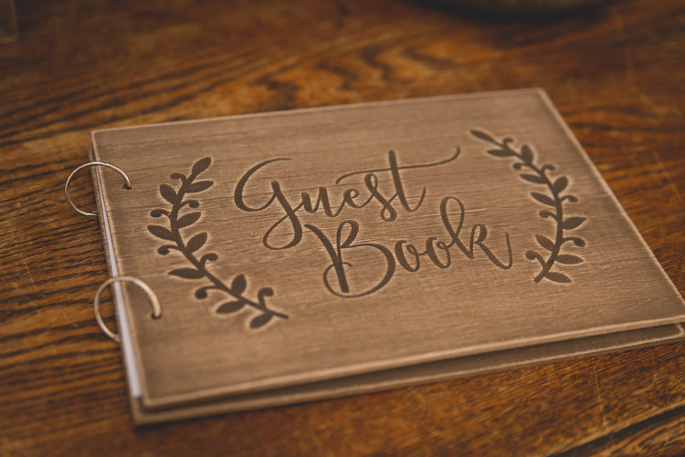 A Wooden Wedding Guest Book Decorated With Engravings.