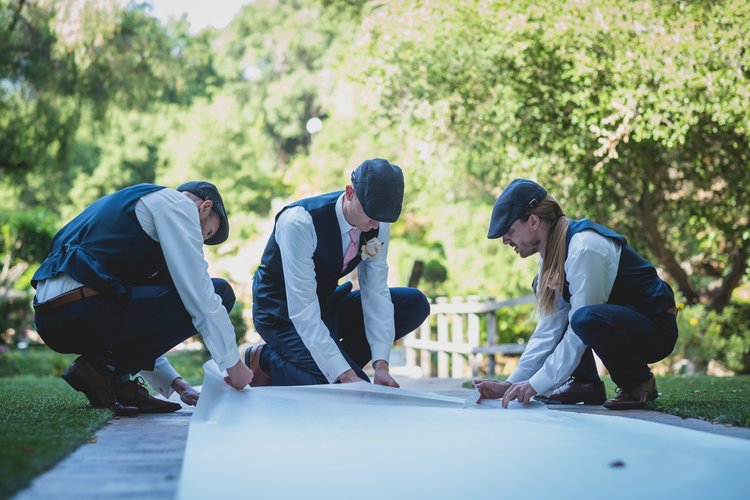 How To Keep Your Bridal Party Informed: A Guide To Keeping Everyone In The Loop - Groomsman Helping Decorate For The Ceremony.