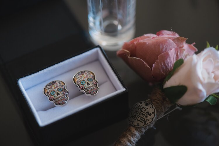 Skull Shaped Cuff Links With Bright Blue Eyes And A Day Of The Day Design.