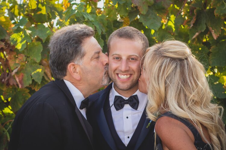 Parents Of The Groom Kissing Him On Each Cheek