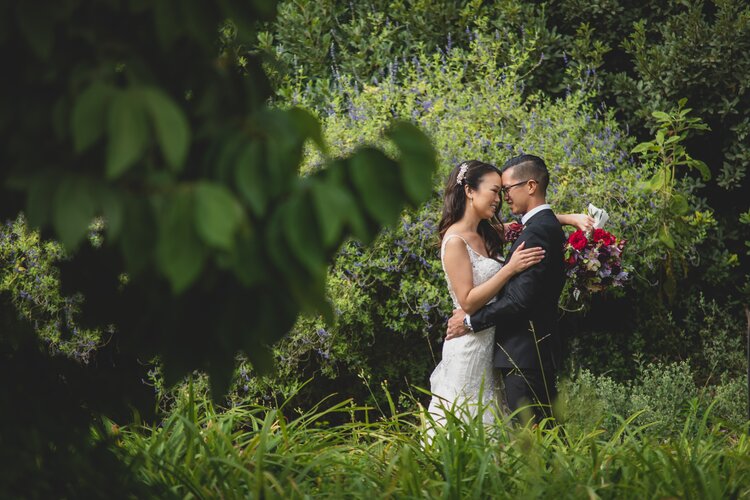 A Newlywed Couple In A Lush Green Garden.