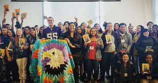 group of Tanaya's students holding her book and an eagle star quilt